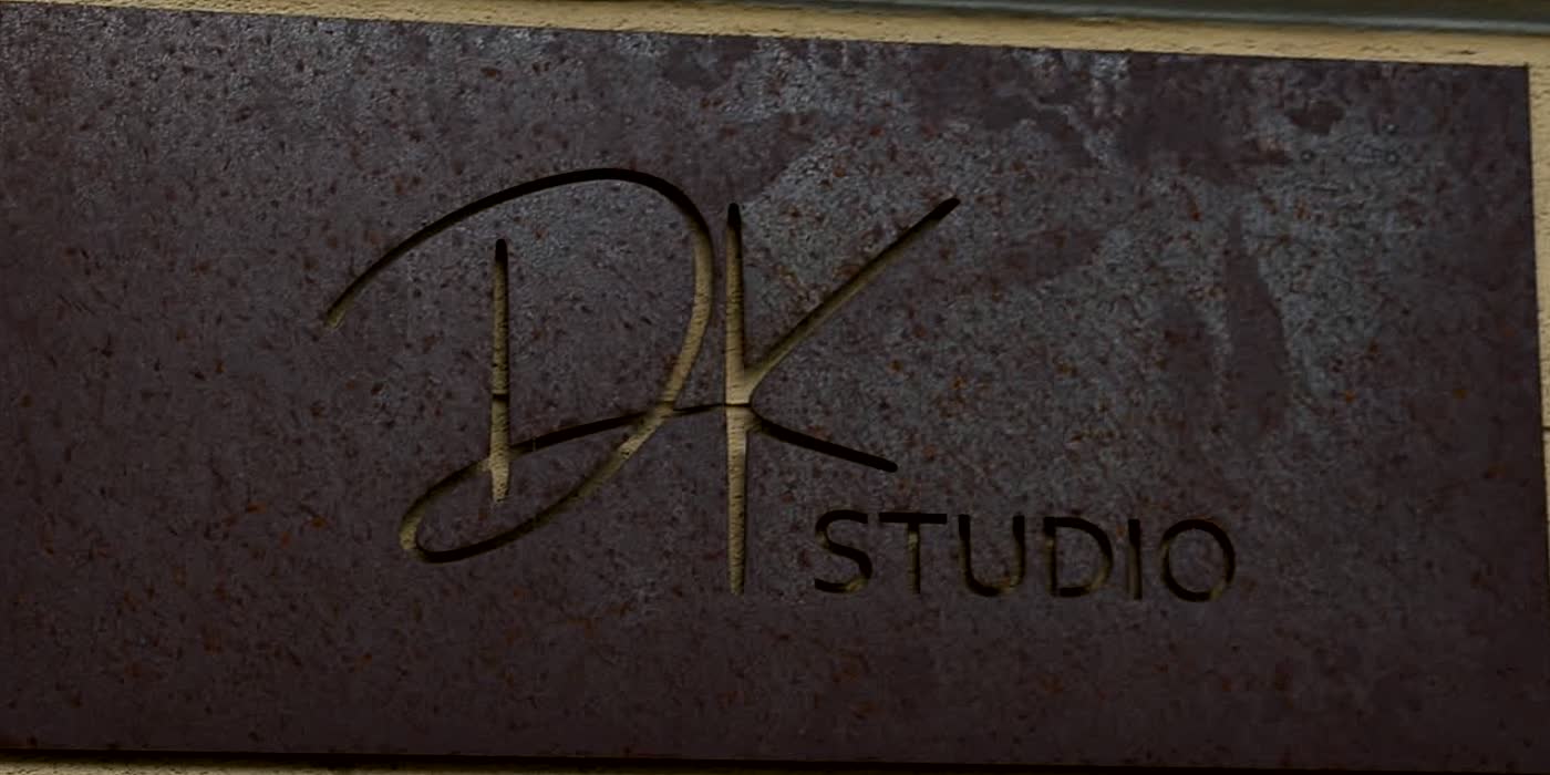 Placa de oțel oxidat cu logoul DK Studio, montată pe fațada clădirii