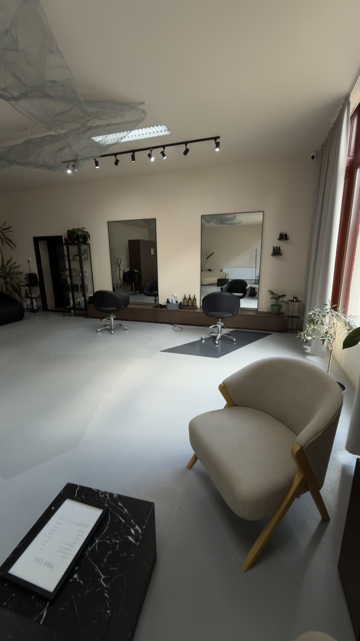 Sala principală a salonului, cu oglinzi și fotoliu de așteptare